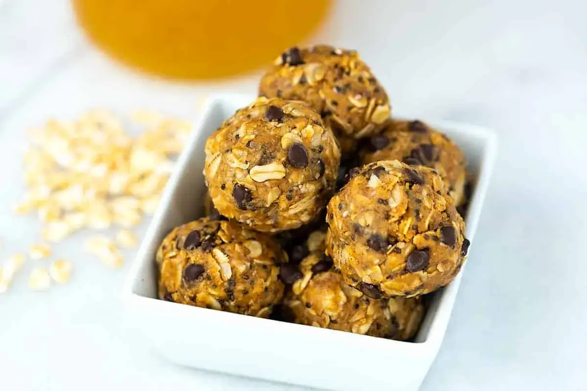 Ein weißes Schälchen voller leckerer Energy Balls mit Haferflocken und Schokostückchen.
