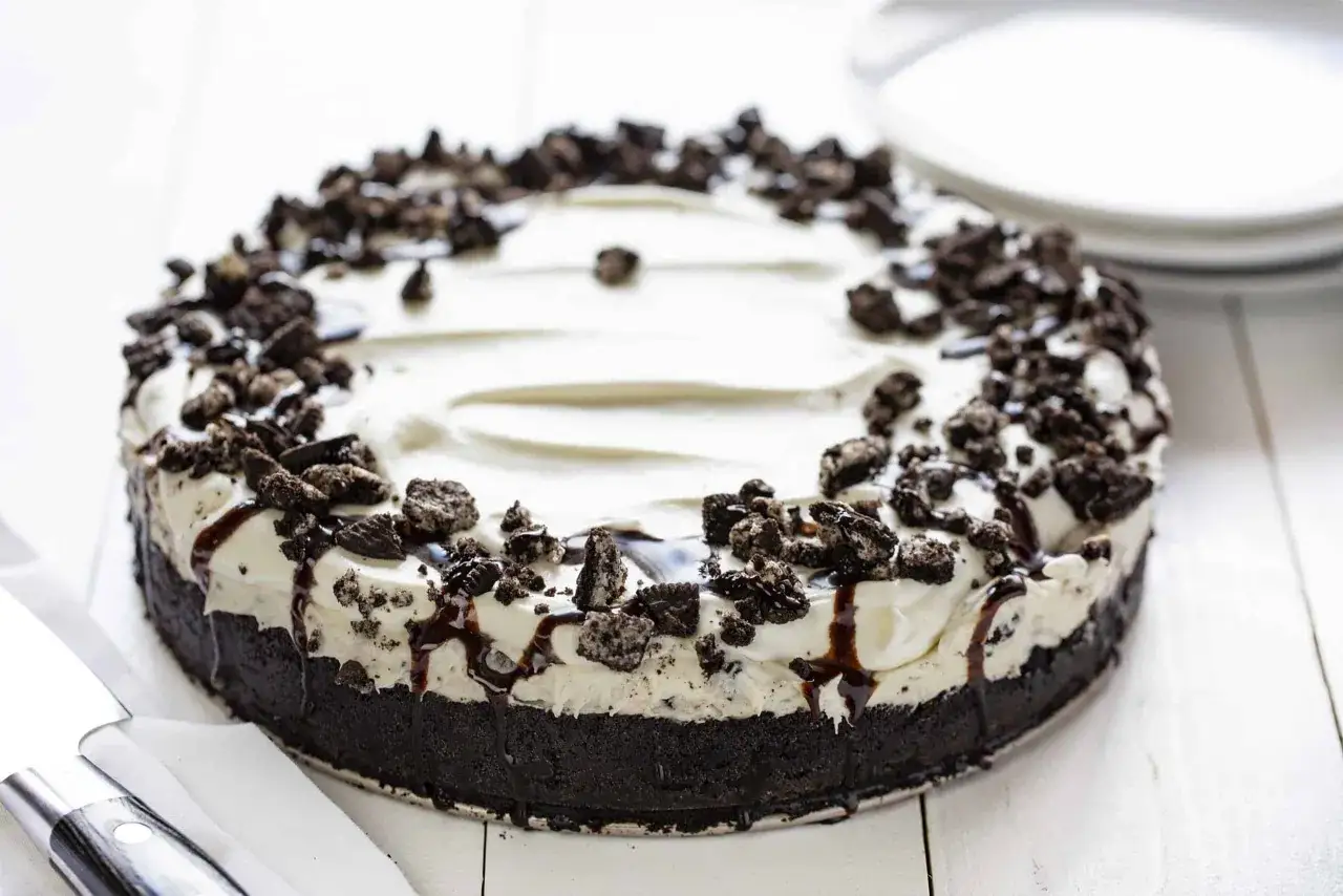 Ein k&ouml;stlicher Oreo Kuchen mit cremiger F&uuml;llung und Schokoladensauce, bestreut mit Oreo-Kr&uuml;meln.