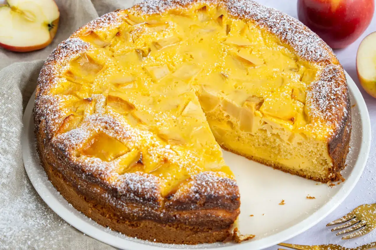 Ein saftiger Apfelkuchen mit Quark, bestäubt mit Puderzucker. Ein Stück fehlt bereits, bereit zum Genießen.