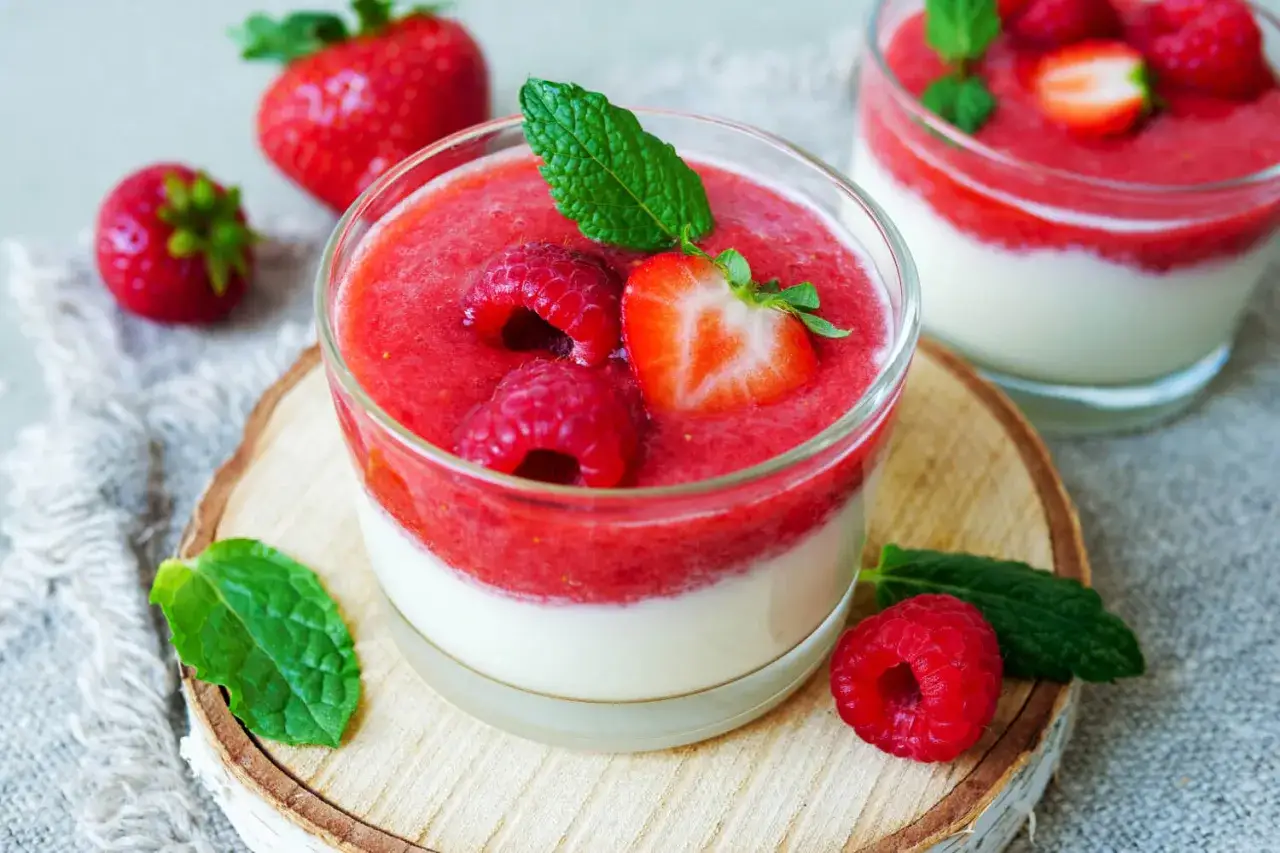 Leckeres Quarkspeise Rezept: Cremige Quarkspeise mit Erdbeerpüree, garniert mit frischen Beeren und Minze.