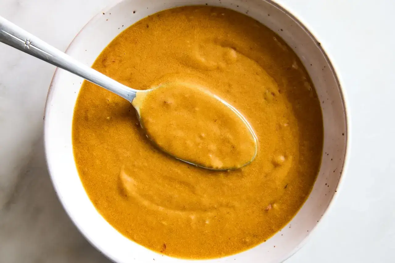 Cremige Erdnusssauce in einer Schüssel, bereit für ein köstliches erdnusssauce rezept. Ein Löffel ruht darin.