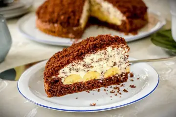 Ein Stück saftiger Maulwurfkuchen mit Bananen und Sahne. Dieses Maulwurfkuchen Rezept ist ein Genuss!