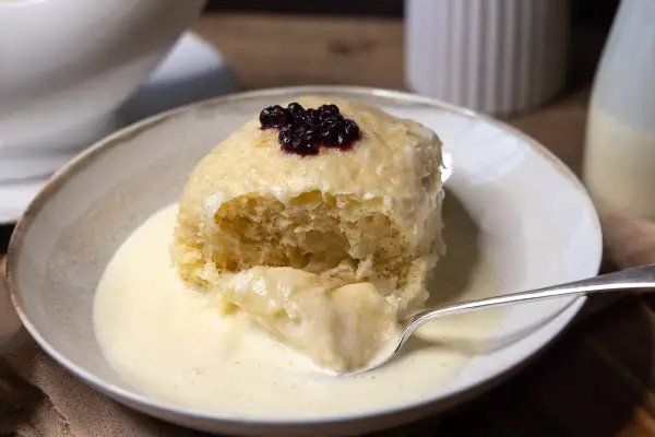 Ein fluffiger Dampfnudel-Kloß mit Blaubeeren und Vanillesauce. Ein köstliches Rezept für Dampfnudeln.