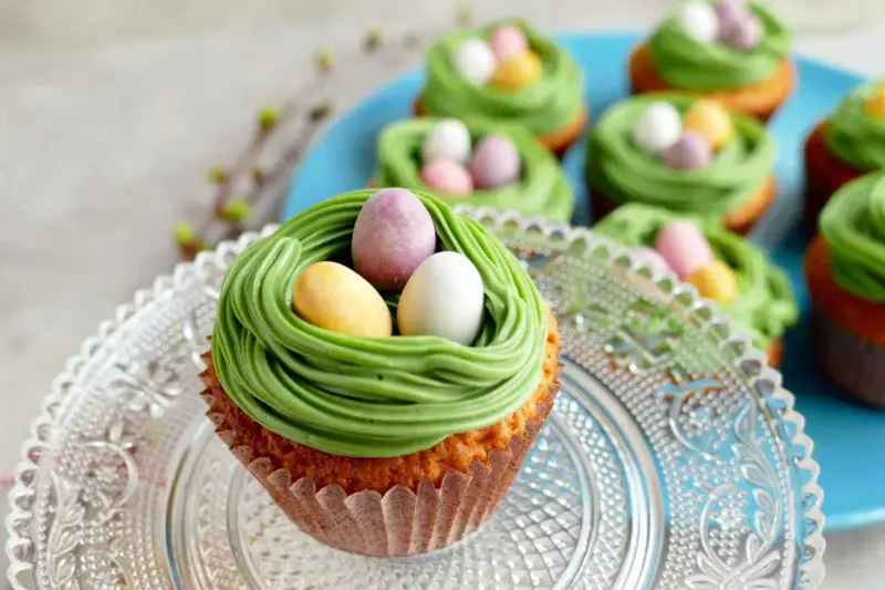 Oster-Cupcakes mit grünem Frosting als Nest und bunten Schokoladen-Eiern.